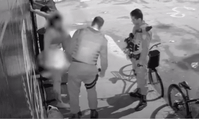 Dois policiais abordam um grupo de quatro pessoas, a jovem aparece sendo submetida a procedimentos que levantaram suspeitas de abuso