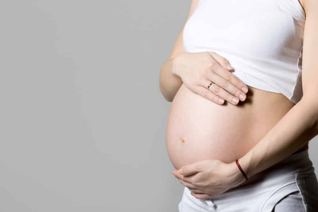 Mulher grávida com a mão na barriga