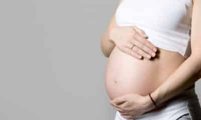 Mulher grávida com a mão na barriga