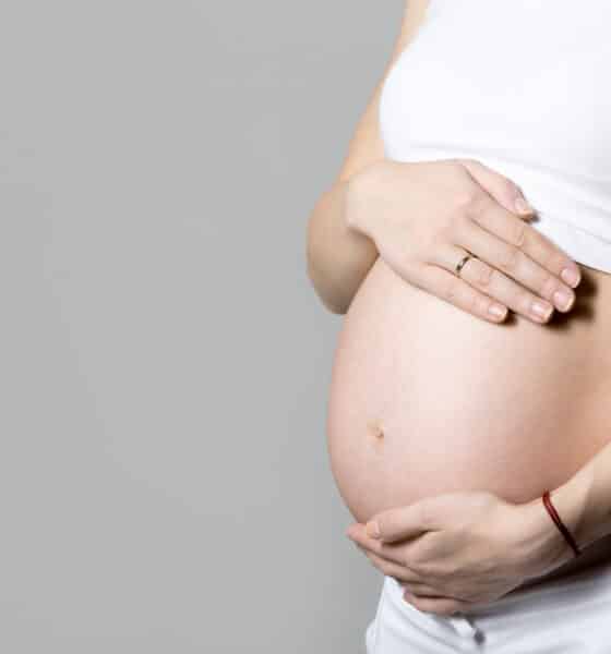 Mulher grávida com a mão na barriga