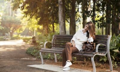 Uma pessoa sentada sozinha em um banco de parque