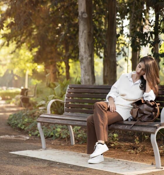 Uma pessoa sentada sozinha em um banco de parque
