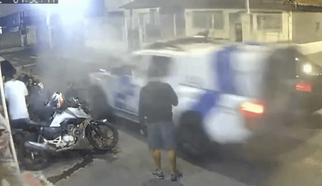 Momento em que policial dispara spray de pimenta de dentro da viatura contra grupo na rua, no bairro José de Anchieta, na Serra